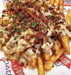 a pile of french fries covered in cheese and bacon