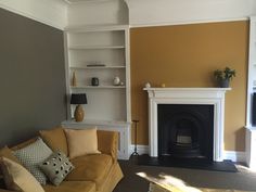 a living room filled with furniture and a fire place in the middle of it's walls