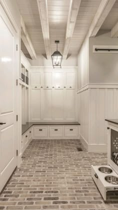 an image of a kitchen with white cabinets and tile flooring on the bottom level