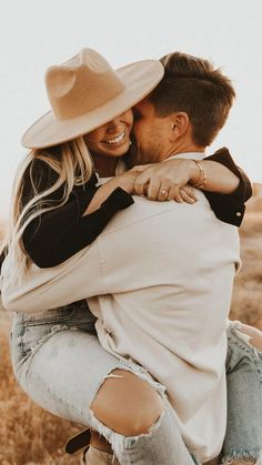 a man and woman hugging each other in a field