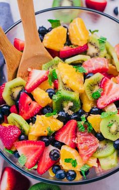 a fruit salad with kiwis, strawberries, oranges and blueberries