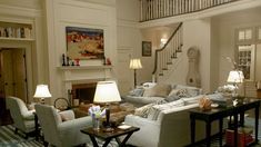 a living room filled with furniture and a fire place under a stair bannister