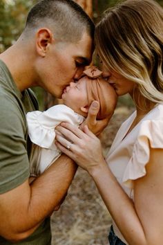 a man and woman kissing each other in the woods