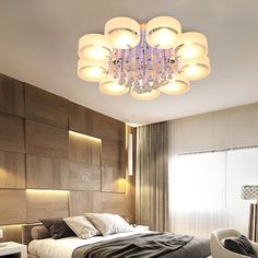 a bed room with a neatly made bed and a chandelier hanging from the ceiling