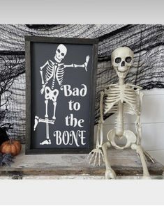 a skeleton sitting next to a sign that says bad to the bone