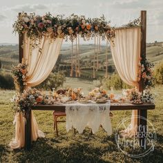 an outdoor table set up with flowers and greenery for a wedding reception in the countryside