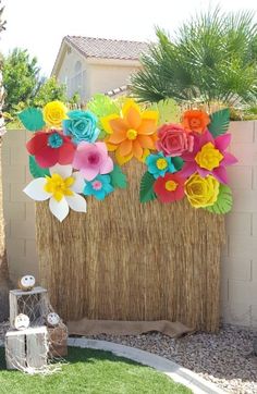 colorful paper flowers are placed on the side of a fence