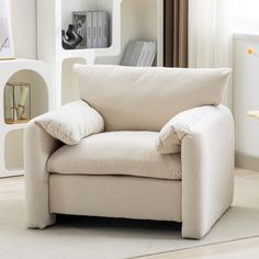 a living room with a white chair and bookshelf