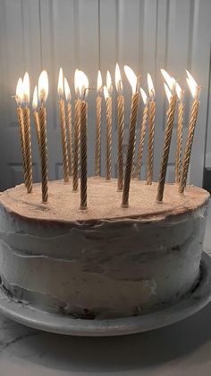 a birthday cake with many lit candles on it