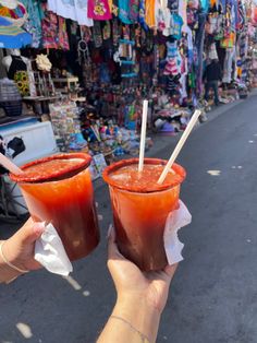 two people holding up drinks in their hands