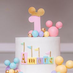 a birthday cake with balloons and mickey mouse topper