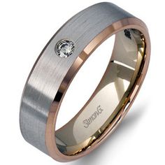 a wedding ring with a diamond in the center and two tone gold accents, on a white background