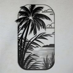 a black and white image of a palm tree on a wall with the ocean in the background