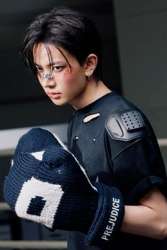 a young man wearing a black shirt and gloves