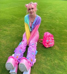 a woman sitting on the grass with her legs crossed