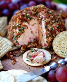 a platter with crackers, grapes and meat