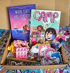 a box filled with books and toys on top of a bed