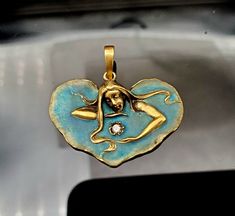 "Beautiful and Romantic Vintage (1990s)  14K Gold heart-shaped blue enamel Art Nouveau style pendant. This VERY sweet pendant measures 1 1/8\" in height (including bail) and 1 1/8\" across as well. This pendant features a Mermaid type girl surrounded by rich sea blue enamel and holding a .05 carat genuine full-cut diamond. To be clear this SPECIFIC item is indeed from the 1990s but I do have the rubber mold on it and can still make others like it in limited quantities. So again to be clear its n Enameled Jewelry, Enamel Art, Heart Shaped Pendant, Detailed Jewelry, Diamond Eyes, Blue Pendant, Art Nouveau Jewelry, Art Nouveau Style, Funky Jewelry