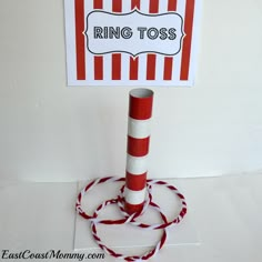 a red and white striped sign on top of a pole with a rope around it