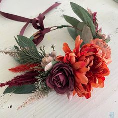 an orange and red flower headband on a white table