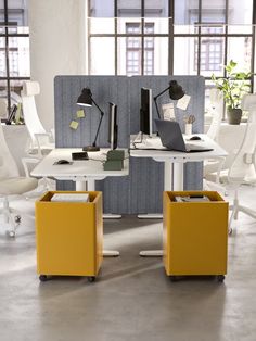 an office cubicle with two desks and chairs in front of them, one is yellow