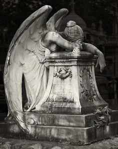 an angel statue sitting on top of a pedestal