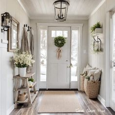 a white front door with wreaths and flowers on the wall next to an entryway