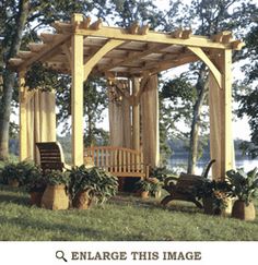 a wooden gazebo sitting on top of a lush green field