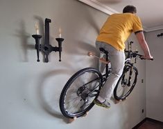 a man on a bike hanging from the wall