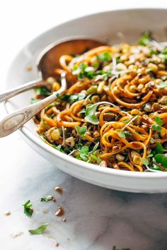 a white bowl filled with noodles and vegetables