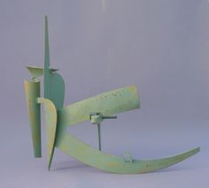 an abstract sculpture made out of green and yellow paint on a gray background with space for text