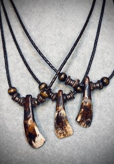 Real buffalo tooth necklace with braided leather cord and a mix of wood, coconut shell, and metal beads. Necklace length is approximately 20 inches with a 3 inch extension chain. Buffalo Tooth Necklace, Rabbits Foot, Tooth Necklace, Bone Horn, Necklace Beads, Coconut Shell, Braided Leather, Beads Necklace, Metal Beads