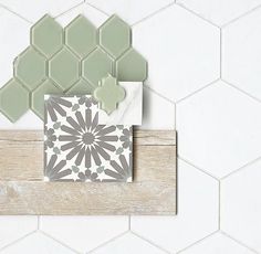 some tiles are laying on top of a wooden board in the shape of hexagonals