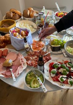 a table full of food and drinks on it, including breads, salads, meats and vegetables