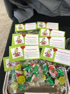 there are many candy candies in the tray on the table with name tags attached to them