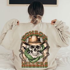 the back of a woman's sweatshirt with an image of a skull wearing a cowboy hat