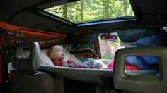 a small child laying in the back of a van