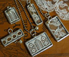 four pieces of jewelry sitting on top of a lace covered tablecloth next to a doily