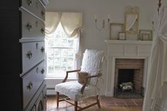 a bedroom with a fireplace, dresser and bed