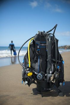 scuba gear on the beach with a man in the background