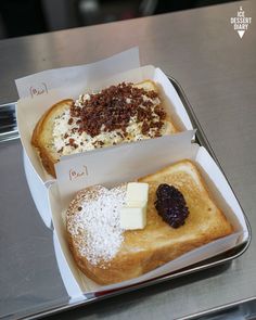 two pieces of bread with different toppings in a box on a counter top next to each other