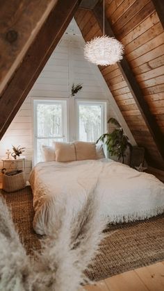 an attic bedroom with white bedding and wooden walls, carpeted flooring, and windows