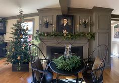 a living room filled with furniture and a fire place covered in greenery next to a christmas tree