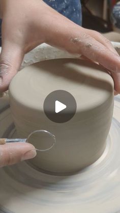 a person is making a pot on a pottery wheel with their thumb in the air