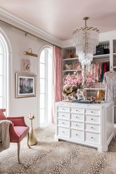 a closet with pink curtains and chandelier hanging from it's ceiling next to a window