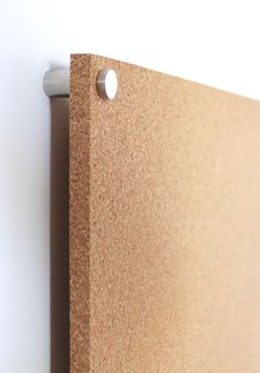 a close up of a cork board with two holes in the middle and one hole at the bottom