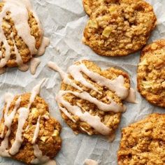 several cookies with icing on top of them sitting on wax paper next to each other