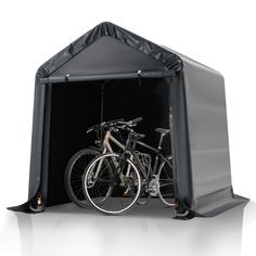 two bikes are parked in the back of a black shelter with tarp on it