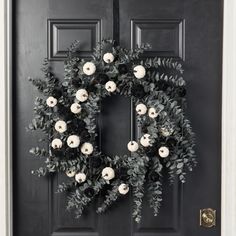 a black door with a wreath on it