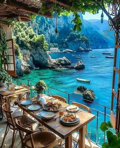 an outdoor dining area overlooking the ocean and boats in the water, with wooden tables and chairs